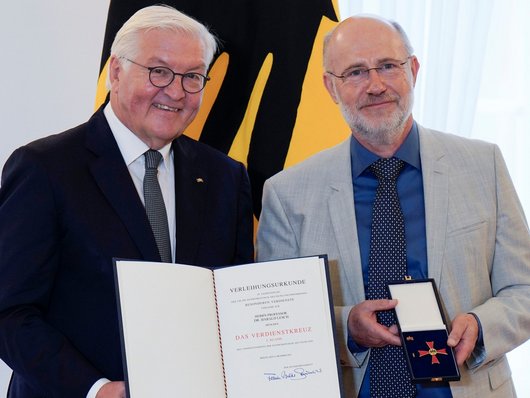 Das Bild zeigt Frank-Walter Steinmeier und Harald Lesch bei der Verleihung des Verdienstkreuzes 1. Klasse. 