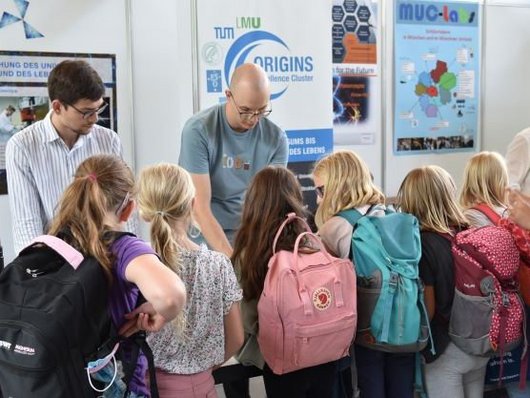 Children in front of the ORIGINS booth at FORSCHA