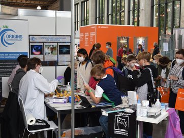 Bild zeigt ORIGINS-Stand auf der FORSCHA.