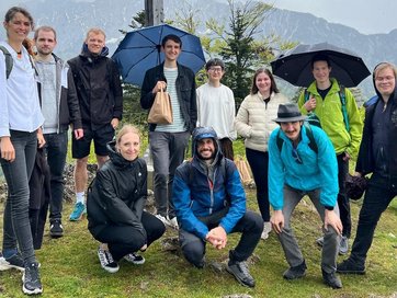 Bild zeigt junge Studierende am Gipfelkreuz.